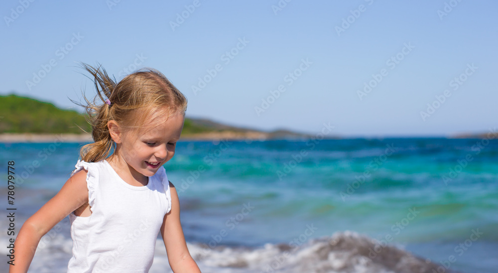 Adorable little girl having fun during tropical beach vacation Adorable little girl having fun during tropical beach vacation