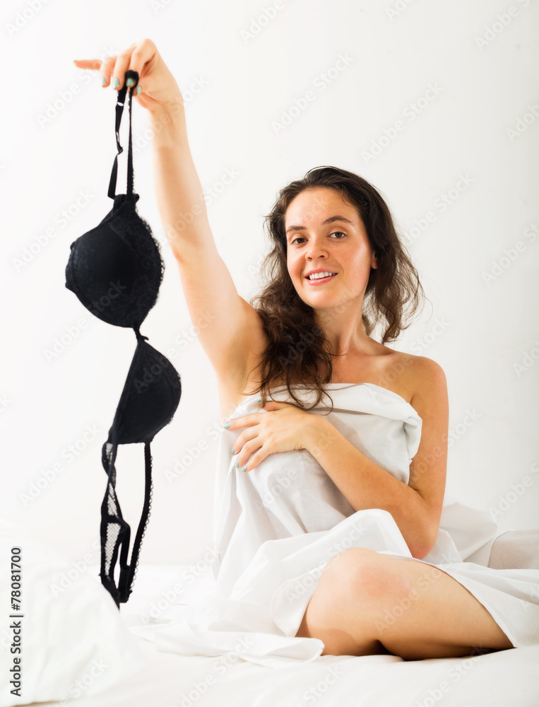 Girl takes off underwear on bed Photos | Adobe Stock