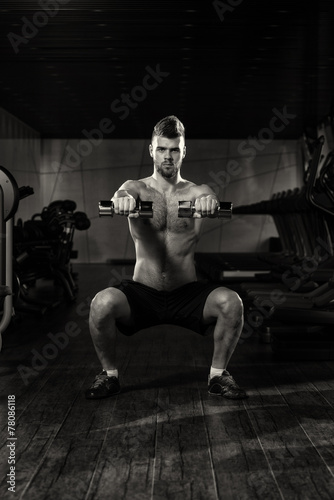 Young Man Doing Exercise Dumbbell Squat