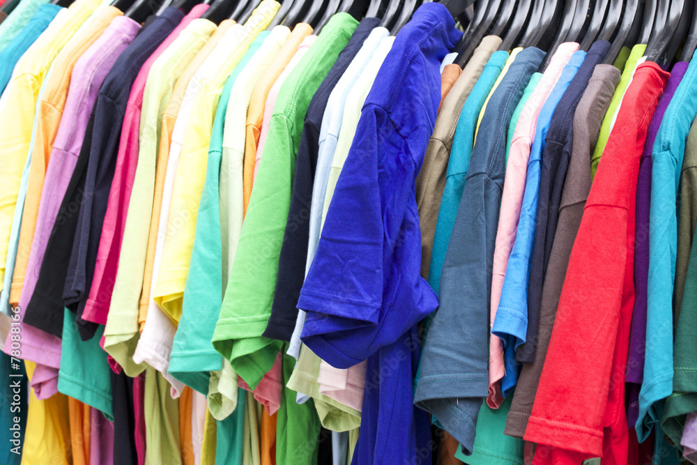 Shop shirts colorful fabric hanging on a rack.