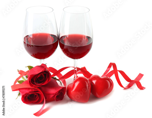 Composition with red wine in glasses, red roses, ribbon and