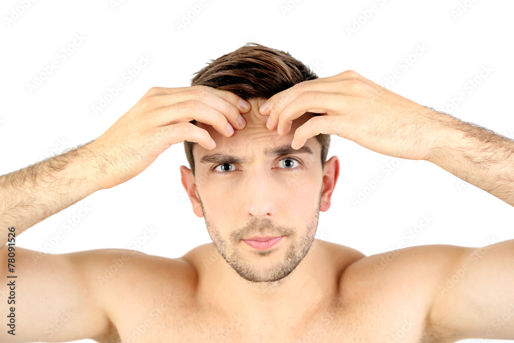 Handsome young man squeezing pimple isolated on white Handsome young man squeezing pimple isolated on white