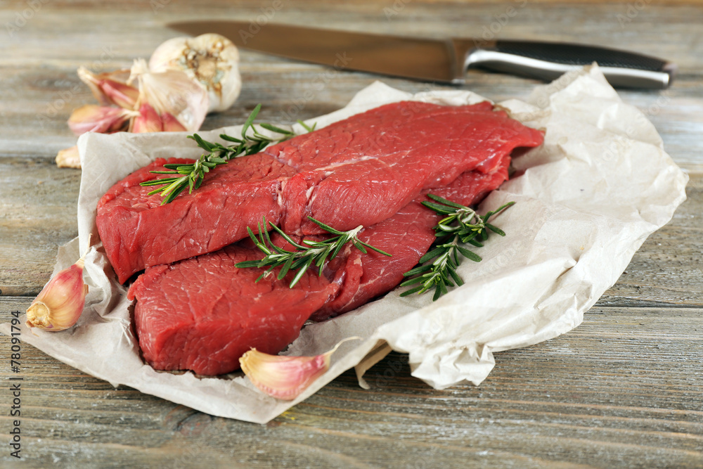 Raw beef steak with rosemary and garlic Raw beef steak with rosemary and garlic