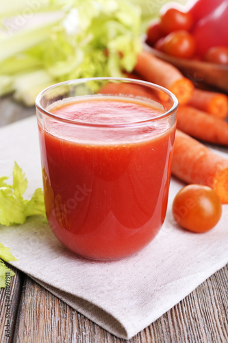 Glass of tomato juice with vegetables on wooden table close up