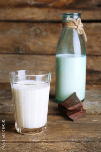 Glass and bottle of milk with chocolate chunks