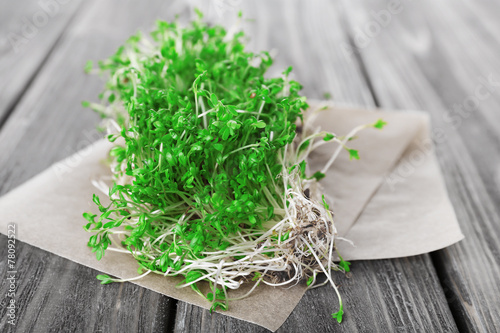 Fresh cress salad on wooden planks background
