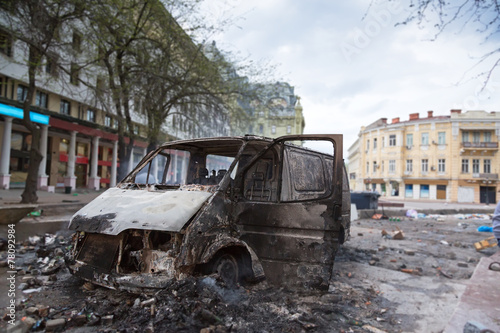 Burned car in the center of city after unrest