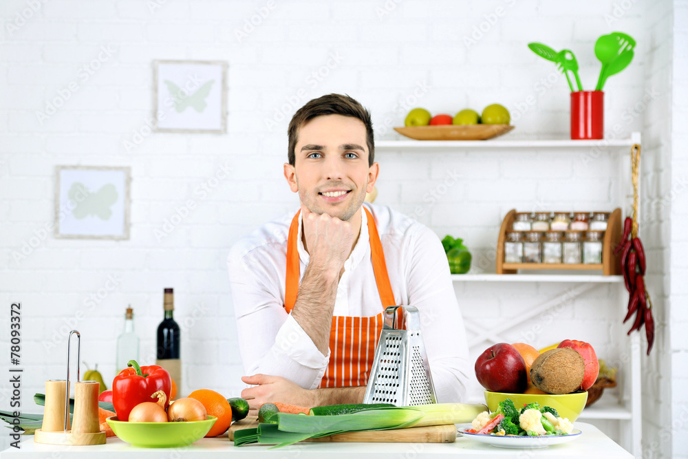 Man at table with different products and utensil in kitchen Man at table with different products and utensil in kitchen