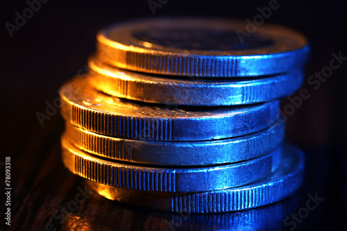 Heap of coins on wooden table, macro view