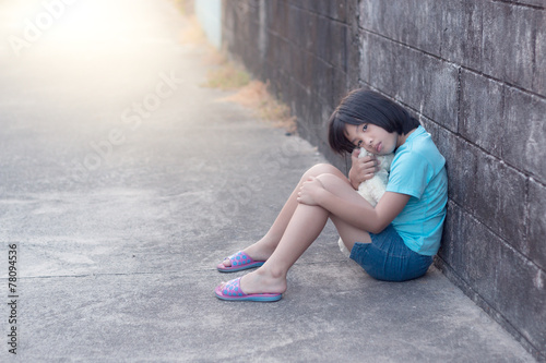 portrait of a sad and lonely Asian girl against grunge wall back