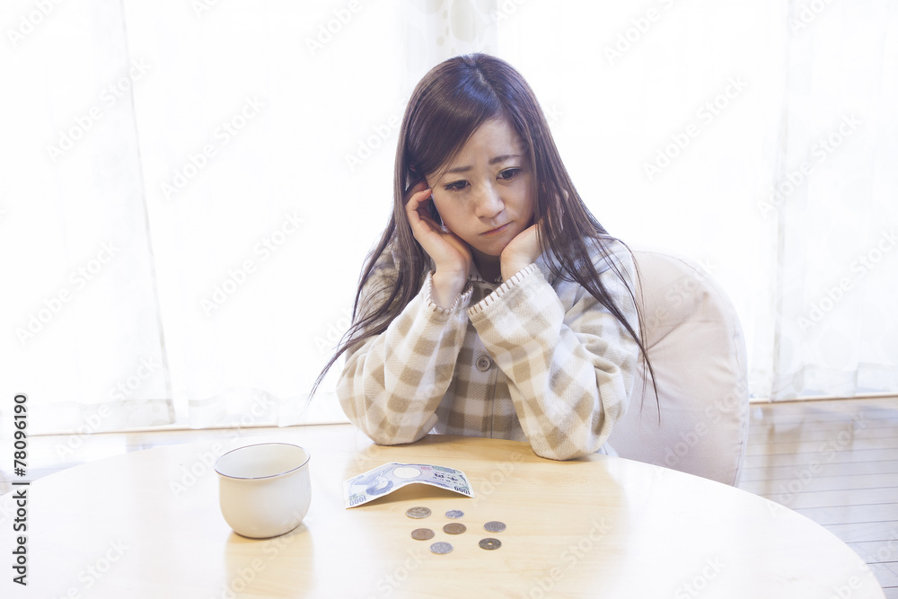 机の上にお金を広げる女性 机の上にお金を広げる女性