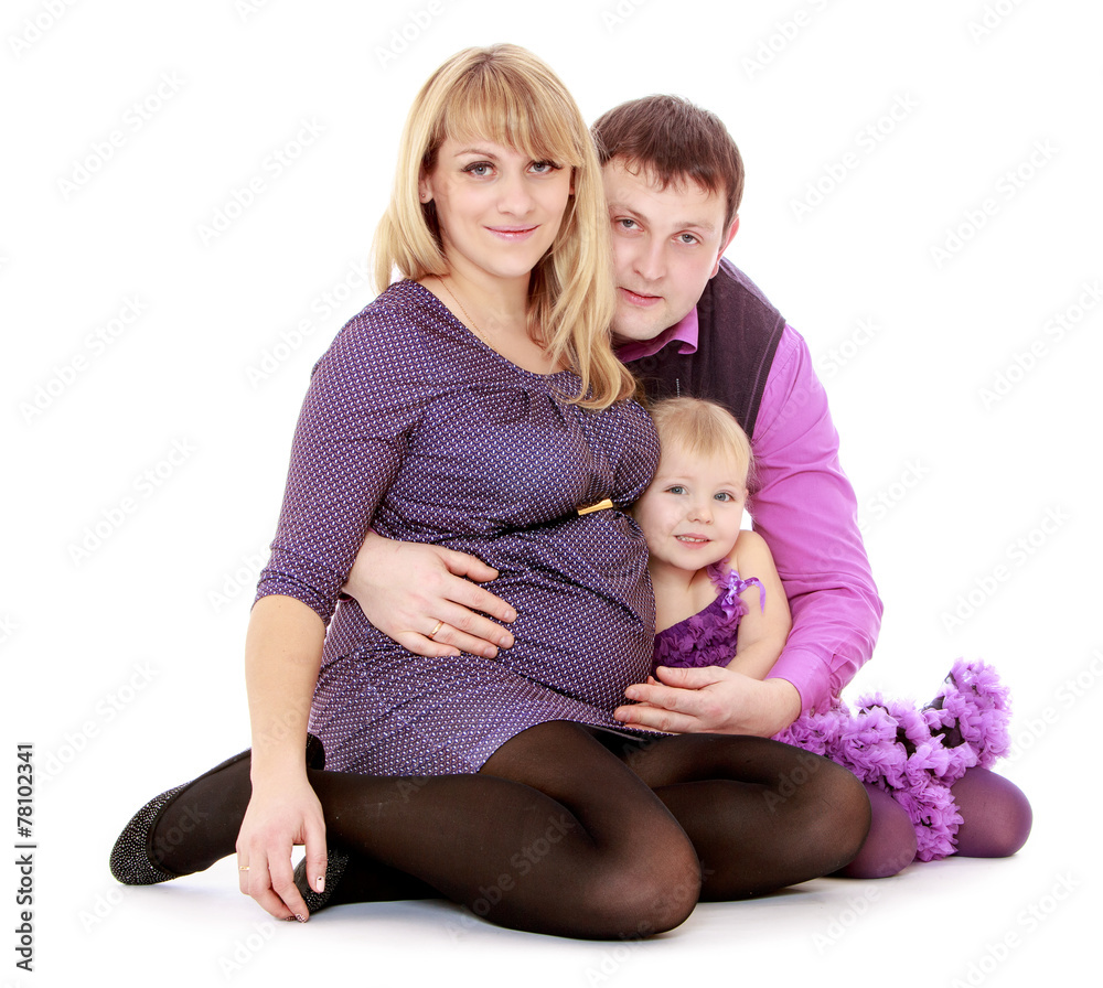 Happy young mother with a tummy into the arms of his beloved fam