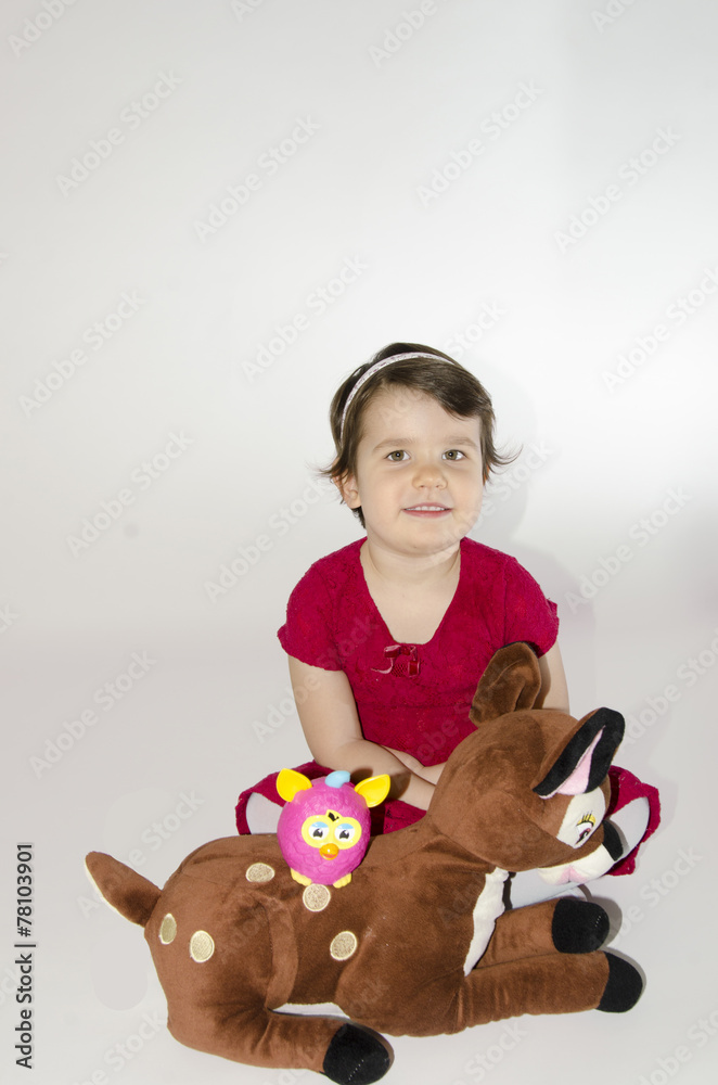 Little girl playing with teddy deer