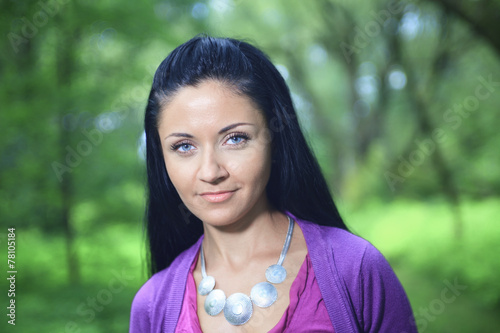 A woman portrait over a green nature background