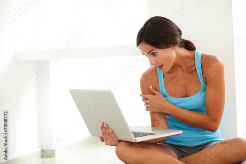 Sitting hispanic female working on her laptop