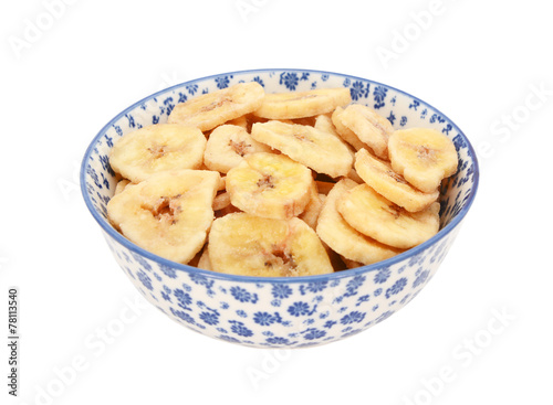 Dried banana chips in a blue and white china bowl