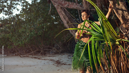 Quadro su tela Indigene woman in the palm skirt on the tropical forest backgrou