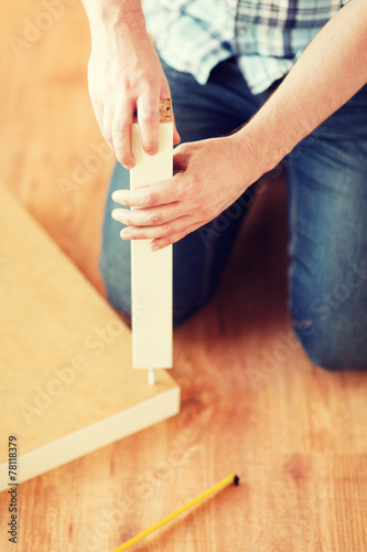 Canvas Print close up of male hands assemblying legs to table