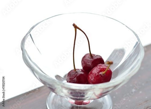 Ice cherry lies in a glass vase photo