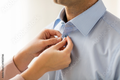 Bilde på lerret close up of man and woman fastening shirt buttons