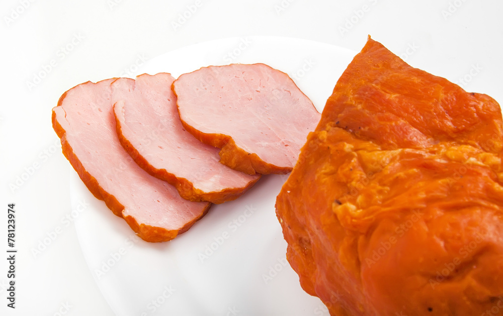 Large piece of ham with cut slices on plate, isolated on white b Large piece of ham with cut slices on plate, isolated on white b