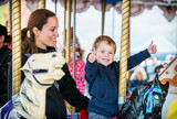 Boy with Two Thumbs Up with Mother on Carousel