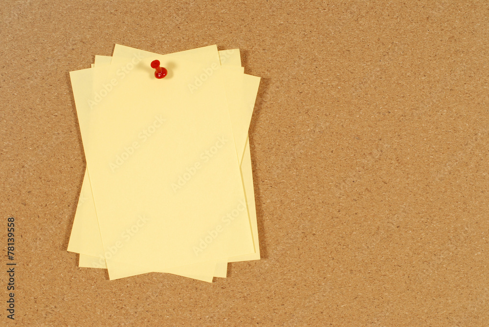 Cluster of yellow post it sticky notes pinned to a cork notice or bulletin board photo