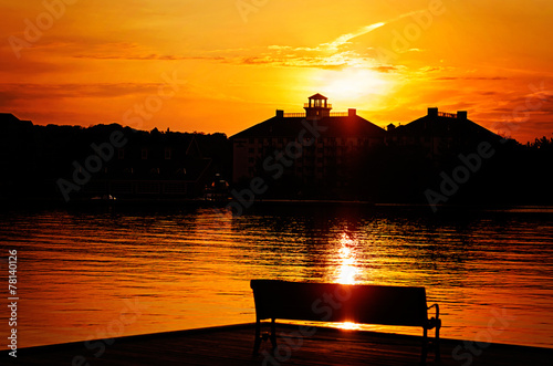 Silhouetted Park Bench By the Lake at Sunset photo