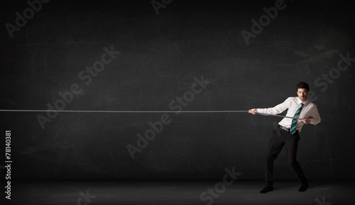 Businessman pulling rope on grey background