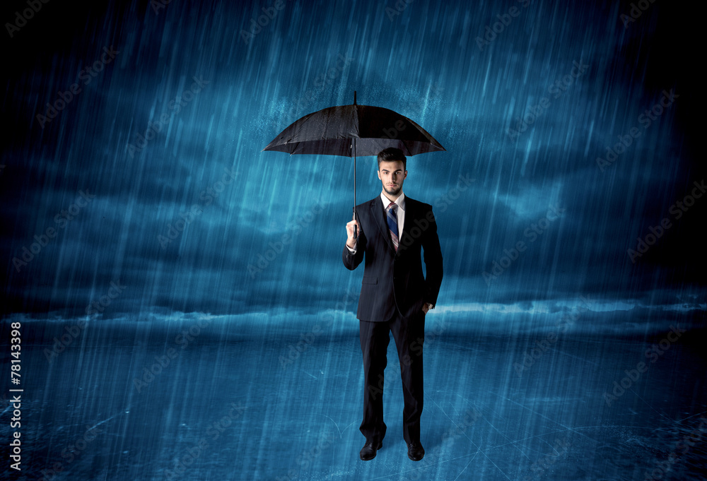 Business man standing in rain with an umbrella Business man standing in rain with an umbrella