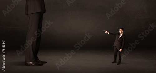 Huge man with small businessman standing at front concept