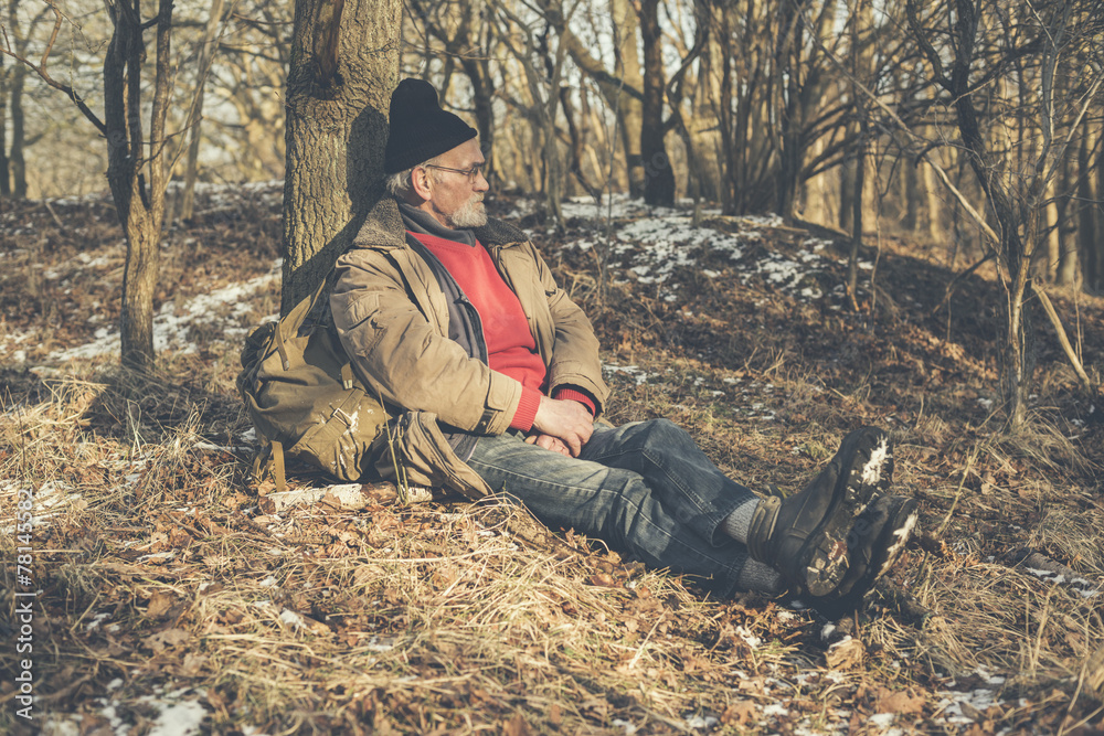 Old Man Resting on the Ground at the Woodland