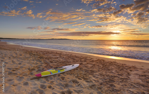 Canvas Print Beach sunrise and paddleboard on shoreline