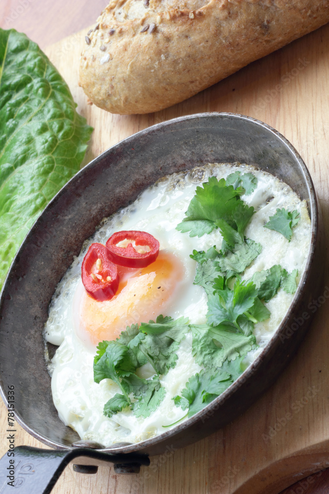 Fried egg with coriander chili and whole grain bun. Fried egg with coriander chili and whole grain bun.