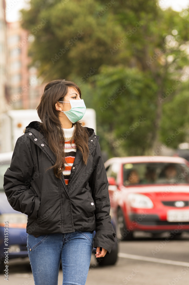 young girl walking wearing a mask in the city street concept of