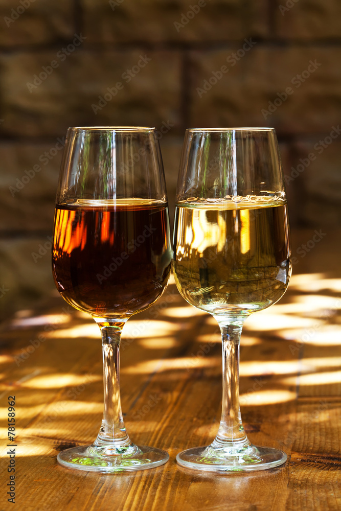 Two glasses of sherry on a wooden table.