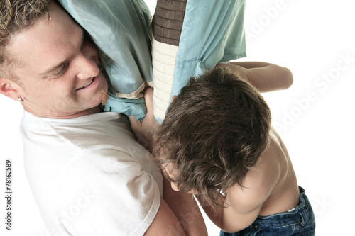 Boy hitting her father with pillow