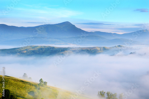 Magic landscape at sunrise in the mountains in the fog