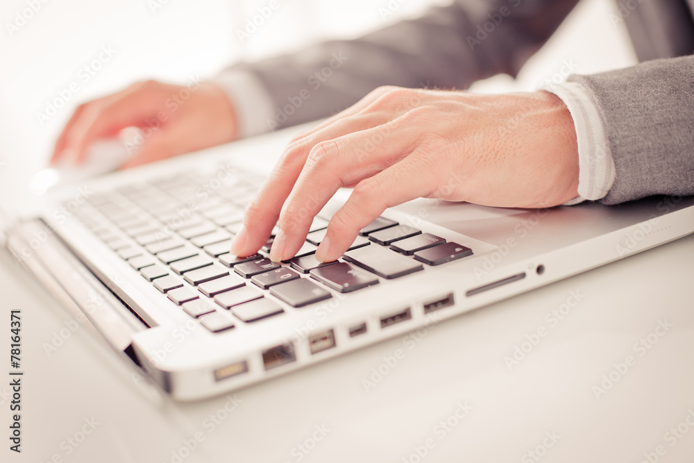 Closeup of businessman hands typing on laptop computer Closeup of businessman hands typing on laptop computer