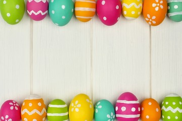 Colorful Easter egg frame against white wood