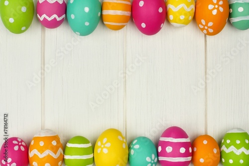 Colorful Easter egg frame against white wood