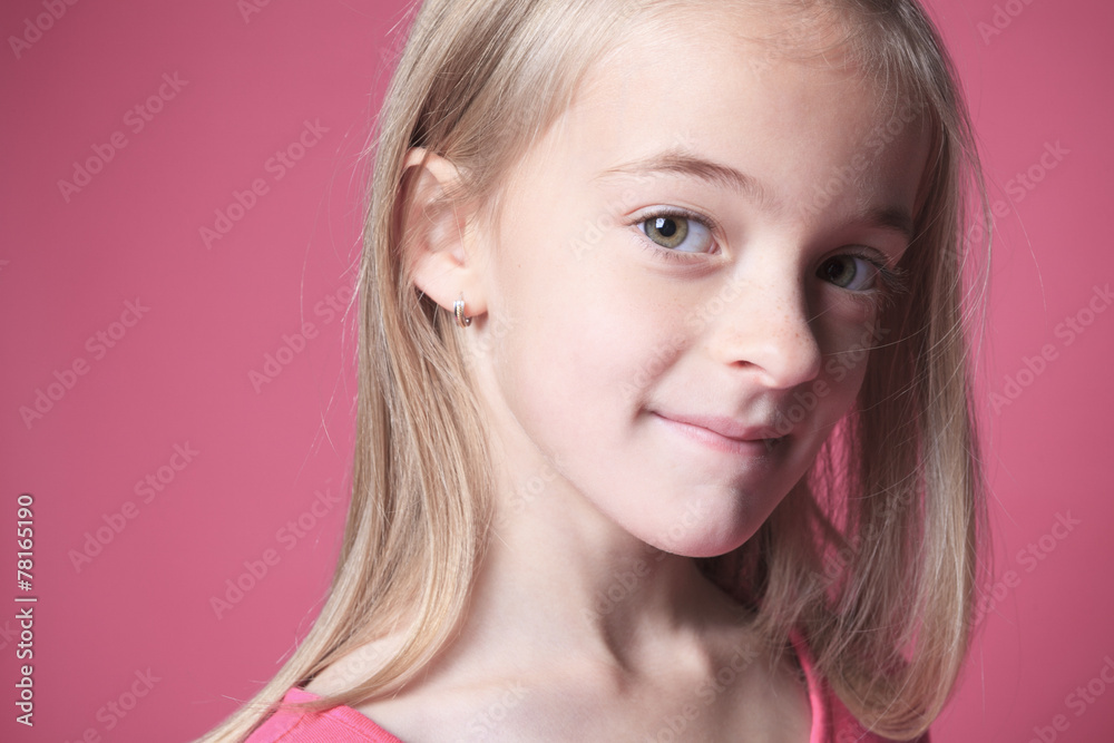 young girl poses for a picture isolated on pink
