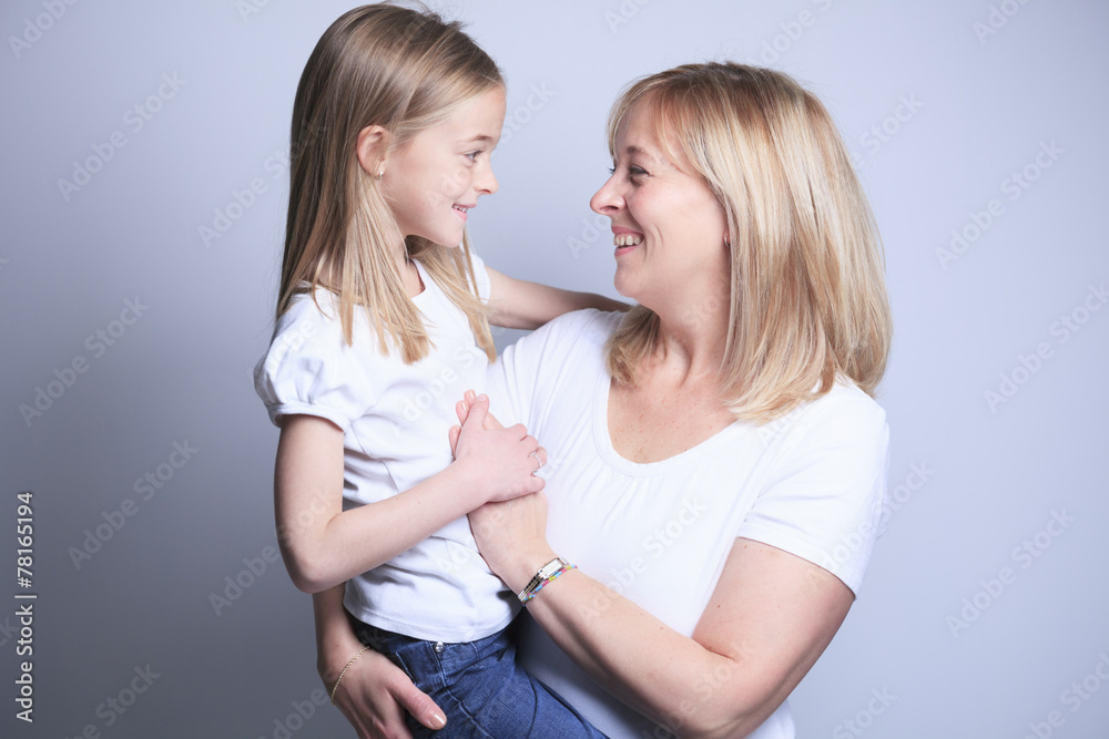 A mother with is daughter over gray background A mother with is daughter over gray background