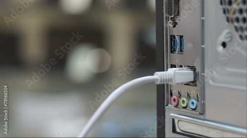 Man connecting LAN network cable into computer, RJ45 connector