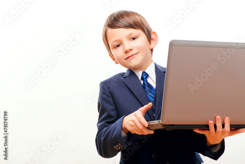 Business child in suit and tie posing with laptop