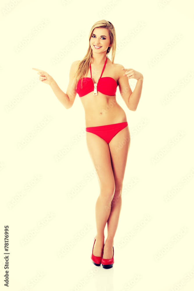 Woman in a swimsuit pointing on copy space Woman in a swimsuit pointing on copy space