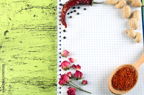 Spices with recipe book on color wooden table background