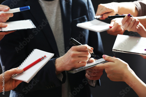 Billede på lærred Elegant man signing autograph in notebook on dark background