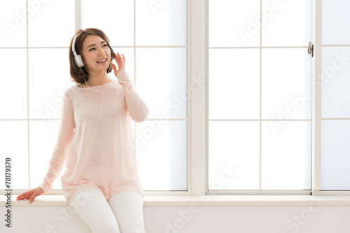 young asian woman listening music 