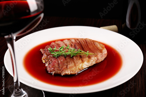 Glass of wine with grilled steak in wine sauce